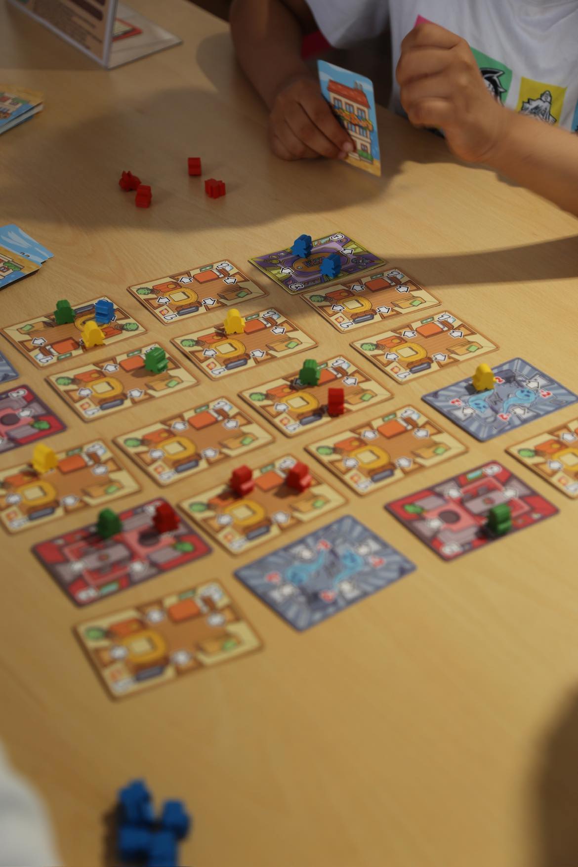 Close-up of Room Share roommate meeples during a chain eviction